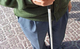 Una persona ciega con un bastón de cirgo.