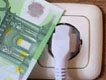 Un billete junto a un enchufe.