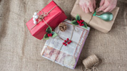 Una persona envuelve varios regalos con papel reciclado.
